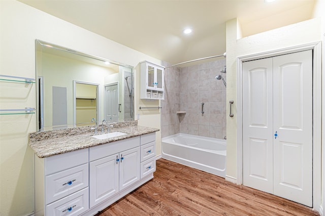 bathroom with vanity, wood-type flooring, and tiled shower / bath combo