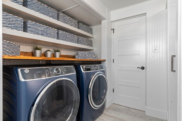 laundry area with washer and dryer and light hardwood / wood-style floors