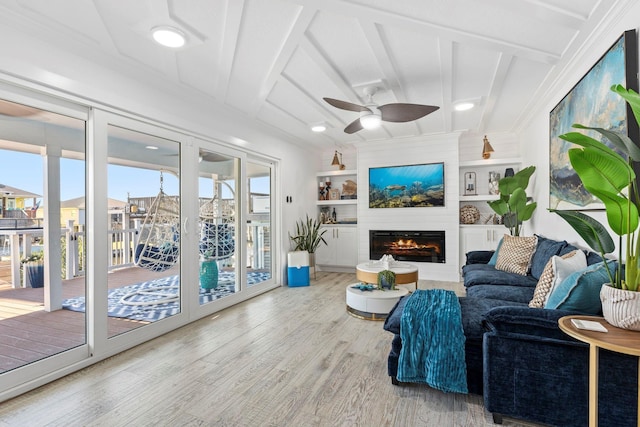 living room featuring light hardwood / wood-style flooring, ceiling fan, built in features, a fireplace, and beam ceiling