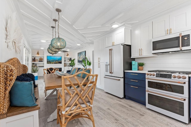 kitchen featuring light wood-type flooring, a textured ceiling, pendant lighting, high quality appliances, and white cabinets