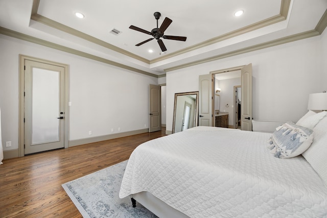 bedroom featuring ornamental molding, dark hardwood / wood-style floors, and a raised ceiling