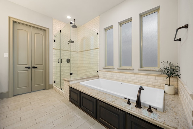 bathroom featuring wood-type flooring and separate shower and tub