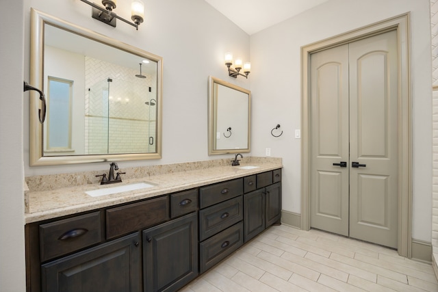 bathroom with vanity and a shower with door