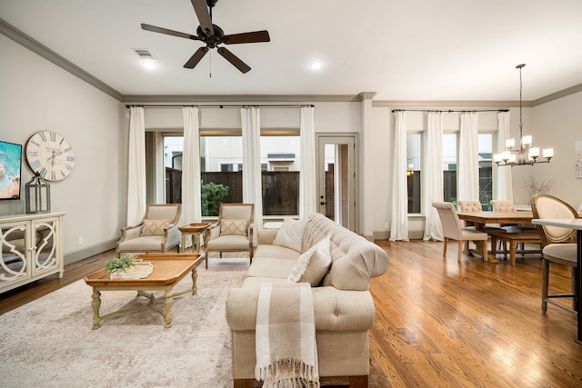 living room with crown molding, ceiling fan with notable chandelier, and hardwood / wood-style flooring