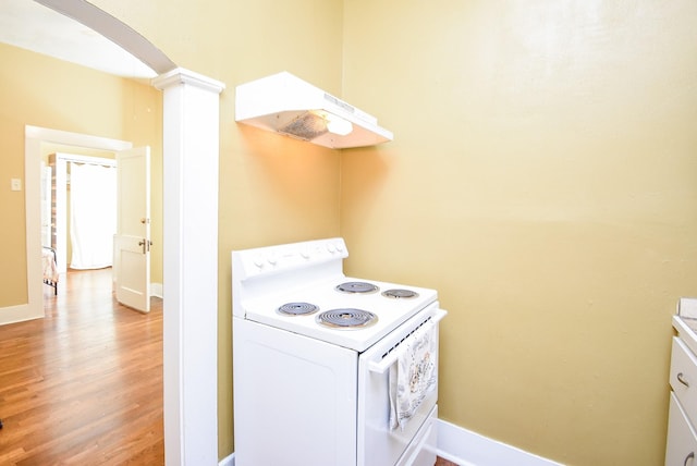 kitchen with ventilation hood, white range with electric stovetop, wood-type flooring, and ornate columns