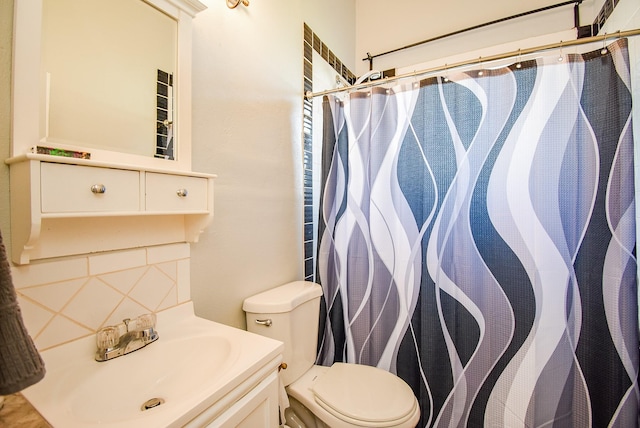 bathroom with decorative backsplash, a shower with curtain, vanity, and toilet