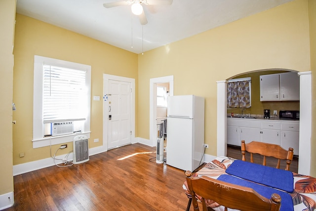 dining area featuring ceiling fan, dark hardwood / wood-style floors, cooling unit, and sink