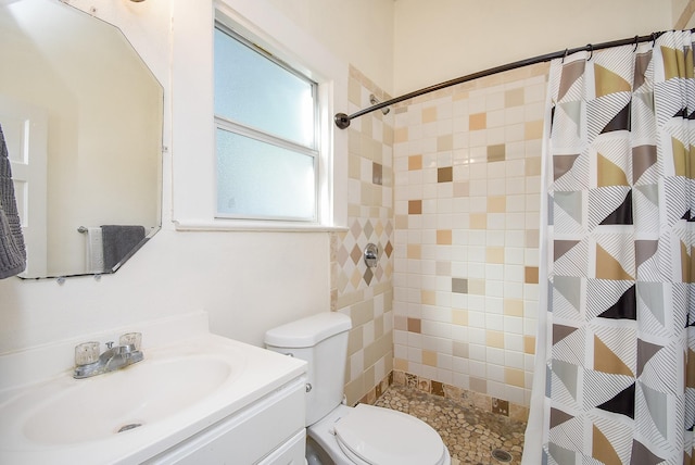 bathroom featuring a shower with shower curtain, vanity, and toilet