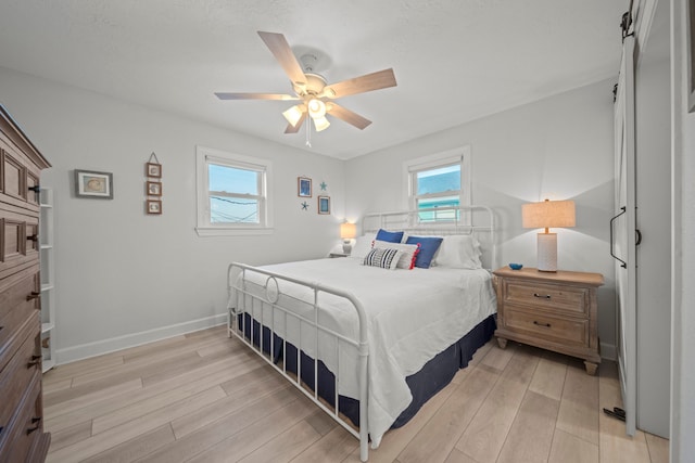 bedroom with ceiling fan and light wood-type flooring