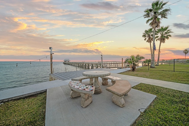 exterior space featuring a boat dock, a yard, and a water view