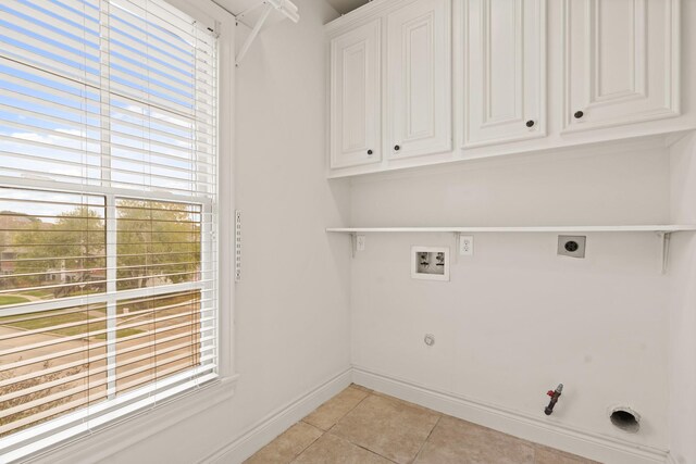 washroom with cabinets, hookup for a washing machine, hookup for an electric dryer, gas dryer hookup, and light tile patterned floors