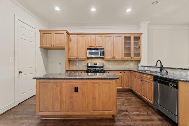 kitchen with sink, dark stone countertops, appliances with stainless steel finishes, dark hardwood / wood-style flooring, and kitchen peninsula