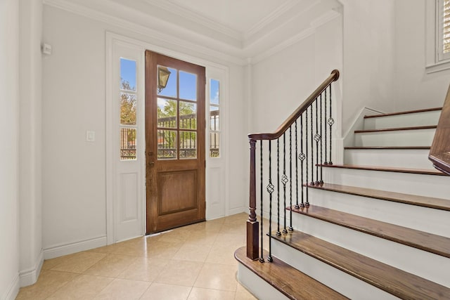 entrance foyer with light tile patterned floors, ornamental molding, and stairs