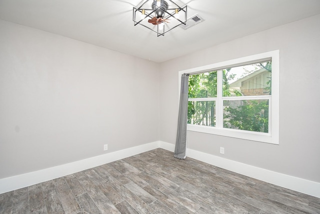 unfurnished room featuring hardwood / wood-style floors and a notable chandelier