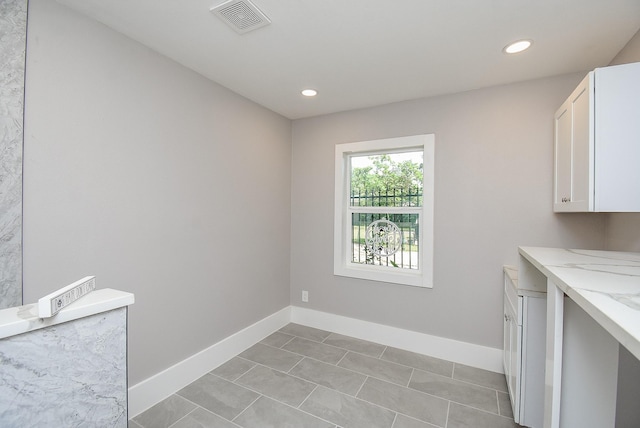 laundry area with light tile patterned floors