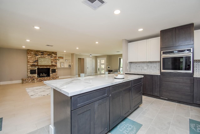7618 Highmeadow Dr, Houston, TX 77063 - kitchen featuring oven, recessed lighting, decorative backsplash, white cabinets, and a kitchen island