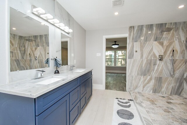 7618 Highmeadow Dr, Houston, TX 77063 - full bathroom with double vanity, a tile shower, wood finished floors, and recessed lighting