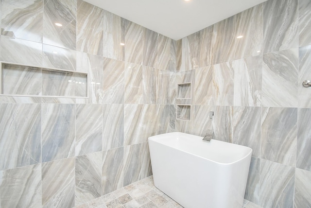 bathroom featuring a tub to relax in and tile walls