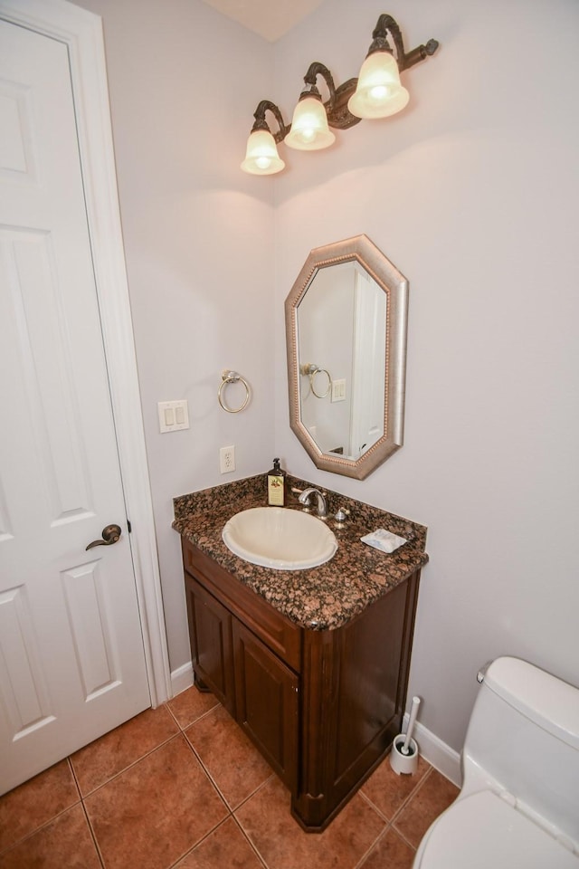 bathroom featuring tile patterned flooring, vanity, and toilet