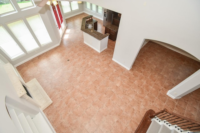 interior space featuring ceiling fan and tile walls