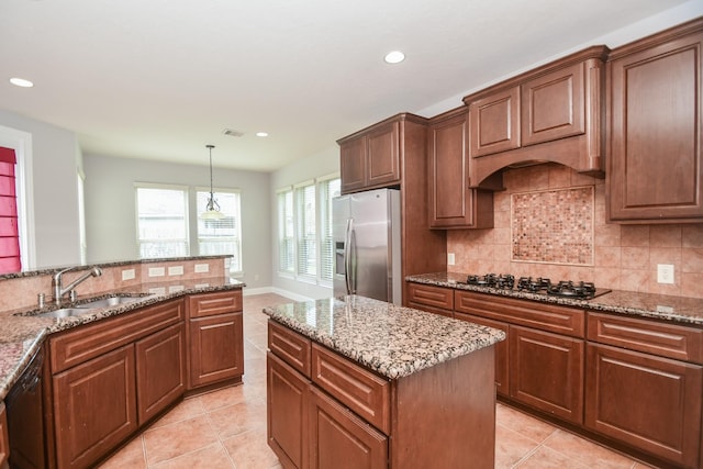 kitchen with sink, dishwasher, hanging light fixtures, gas cooktop, and stainless steel fridge