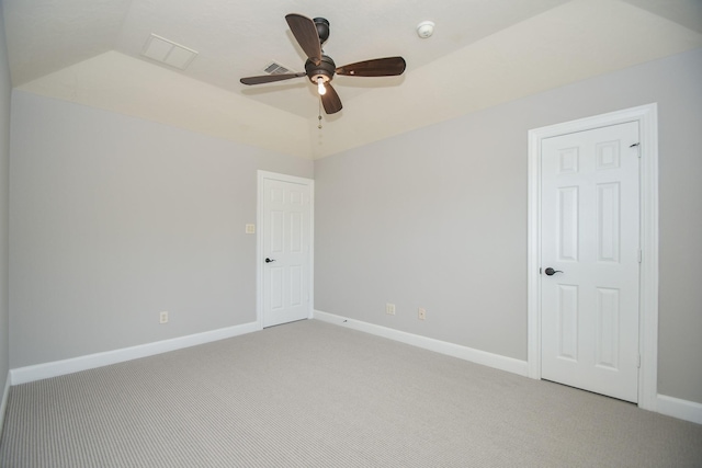 spare room featuring ceiling fan, light colored carpet, and lofted ceiling