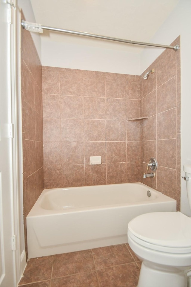 bathroom featuring tile patterned floors, tiled shower / bath, and toilet