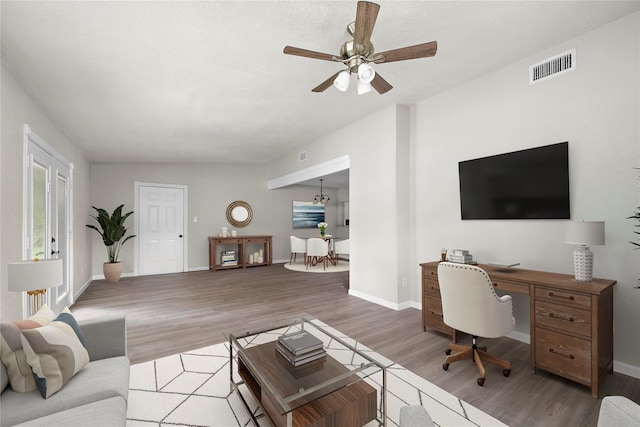 living room featuring ceiling fan, wood-type flooring, and vaulted ceiling