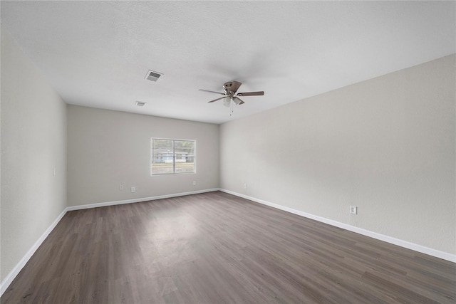 spare room with ceiling fan and dark wood-type flooring