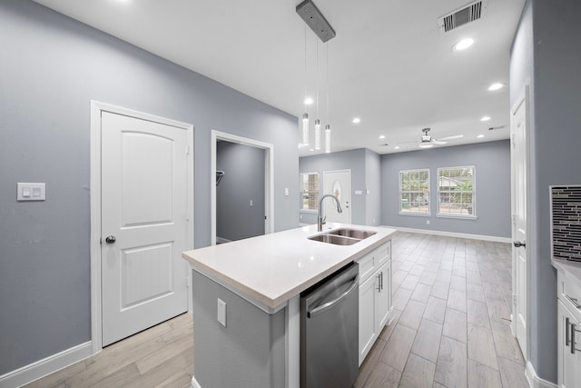 kitchen featuring sink, stainless steel dishwasher, an island with sink, decorative light fixtures, and white cabinetry