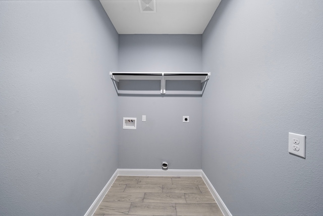 laundry area featuring light hardwood / wood-style floors, washer hookup, and hookup for an electric dryer