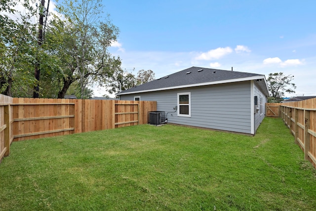 rear view of house with a lawn and cooling unit