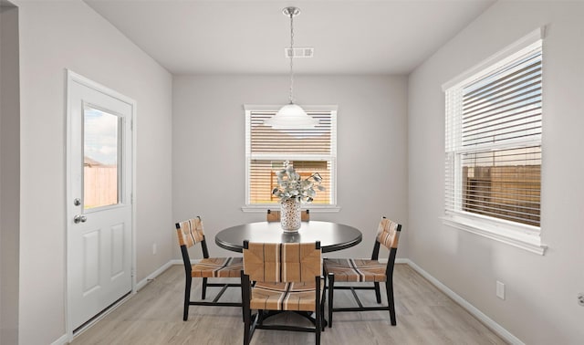 dining room with a healthy amount of sunlight and light hardwood / wood-style flooring