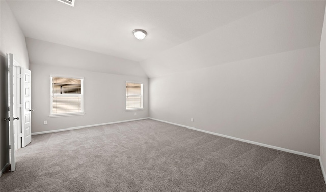 spare room featuring carpet and lofted ceiling