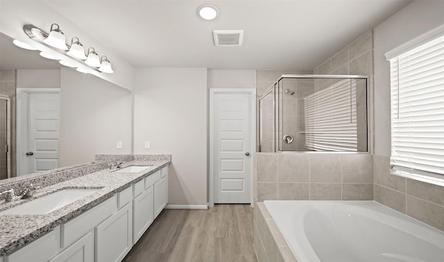 bathroom featuring hardwood / wood-style floors, vanity, and shower with separate bathtub