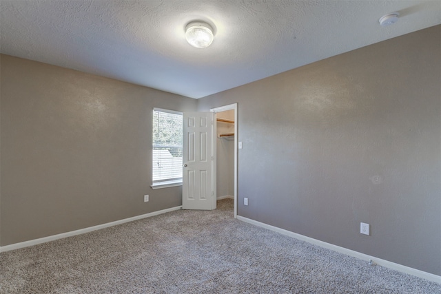 carpeted spare room with a textured ceiling