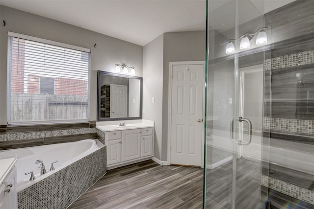 bathroom featuring vanity, wood-type flooring, and shower with separate bathtub