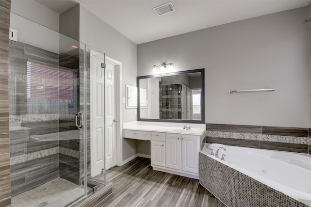 bathroom featuring hardwood / wood-style floors, vanity, plus walk in shower, and a wealth of natural light