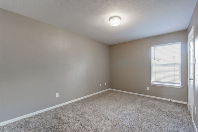 carpeted spare room with a textured ceiling