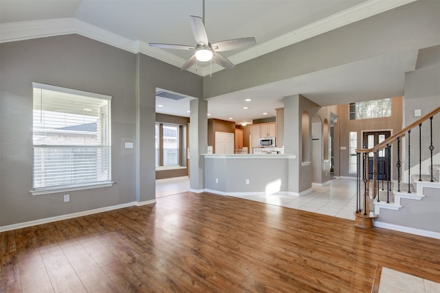 unfurnished living room with ceiling fan, light hardwood / wood-style flooring, lofted ceiling, and ornamental molding