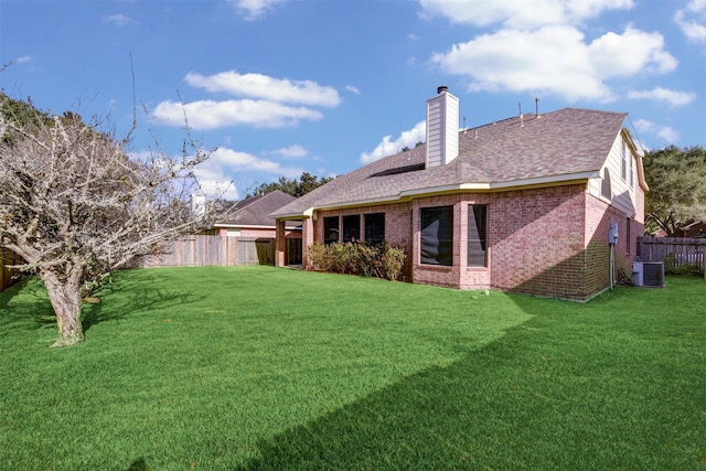 rear view of property with a lawn and central AC