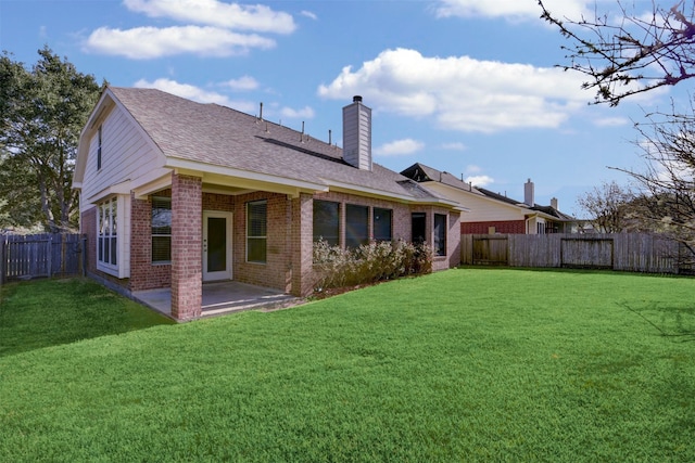 rear view of house featuring a lawn and a patio