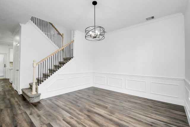 unfurnished dining area with a chandelier, crown molding, and dark wood-type flooring