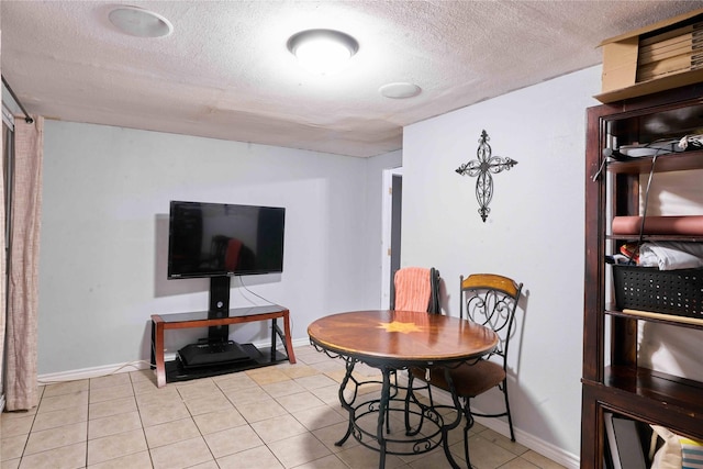 tiled dining space featuring a textured ceiling