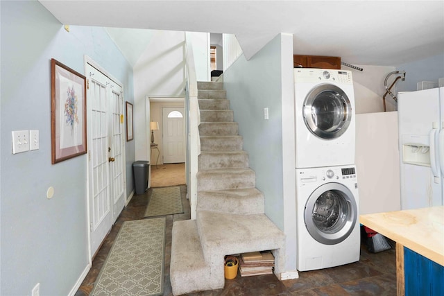 clothes washing area featuring stacked washer and clothes dryer