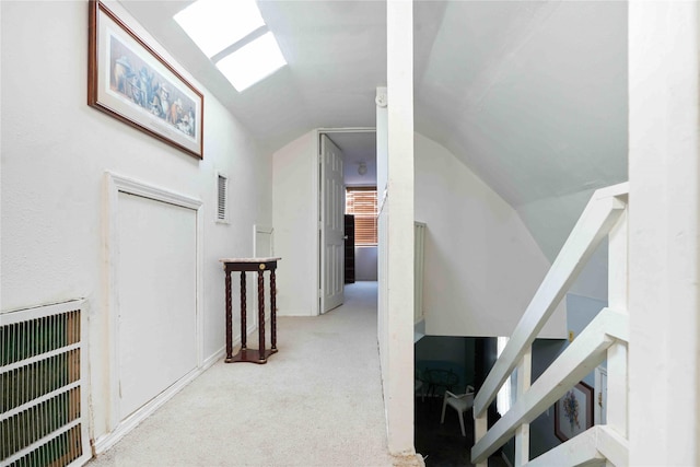 hall featuring light carpet and vaulted ceiling