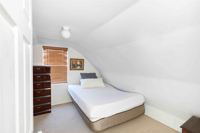 carpeted bedroom featuring lofted ceiling