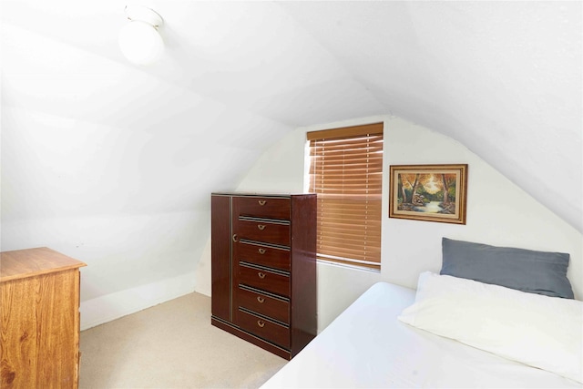 bedroom featuring light carpet and lofted ceiling