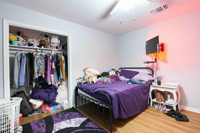 bedroom featuring hardwood / wood-style floors, ceiling fan, and a closet