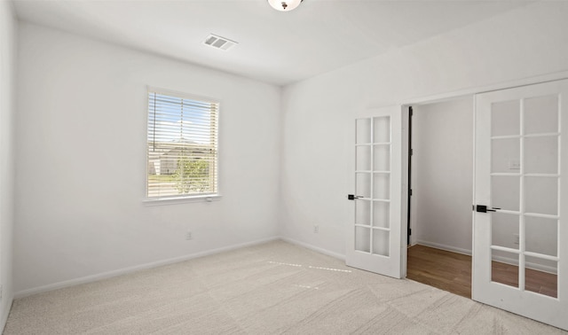 carpeted empty room featuring french doors